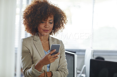 Buy stock photo Cropped shot of a beautiful young businesswoman using her phone in the office
