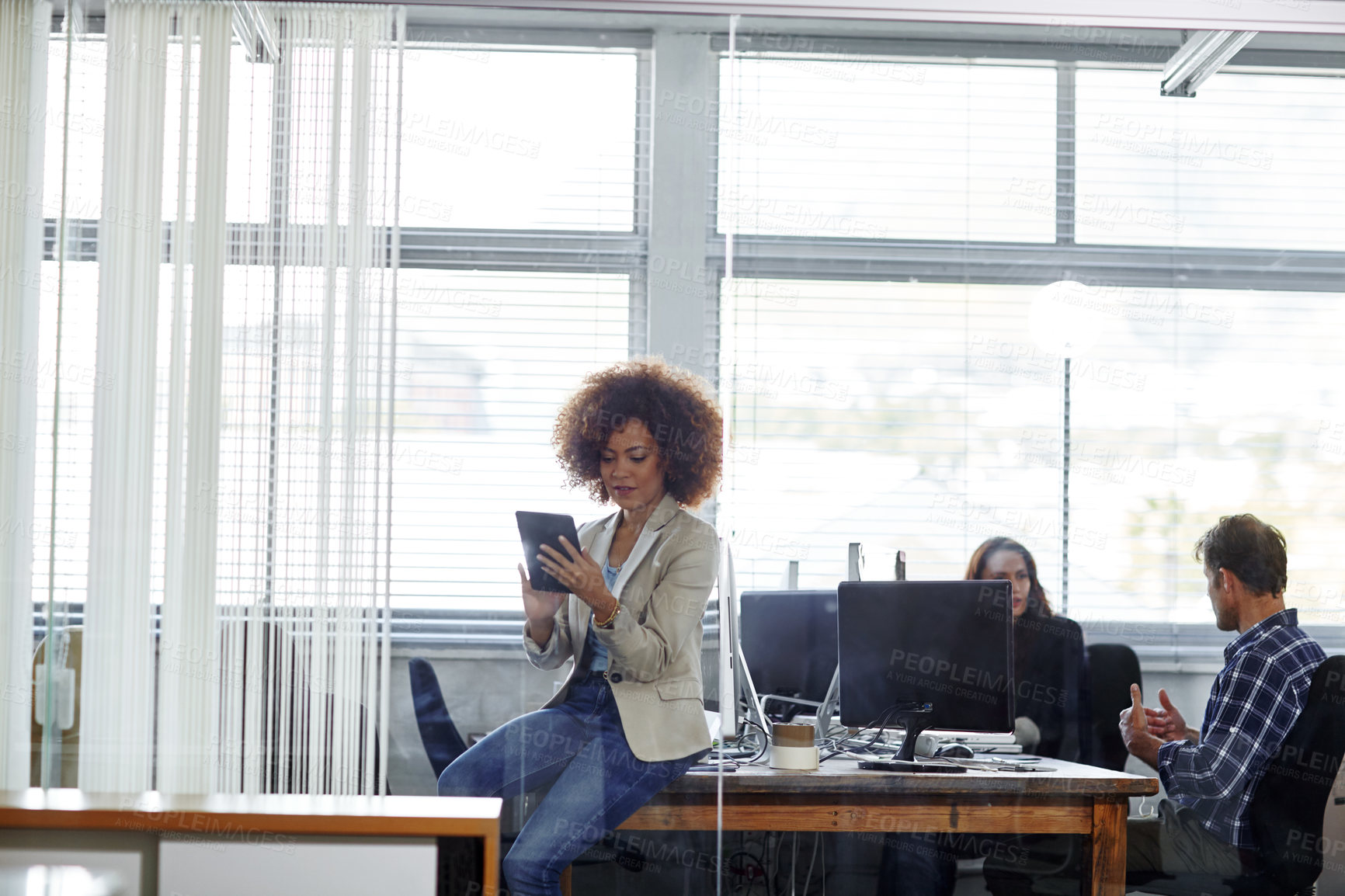 Buy stock photo Cropped shot of a beautiful young businesswoman using her tablet in the office