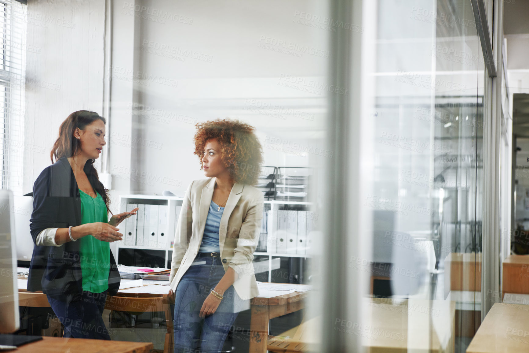 Buy stock photo Shot of two young female designers discussing work in the office