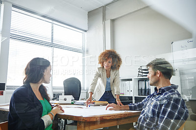 Buy stock photo Cropped shot of three colleagues discussing business in the office