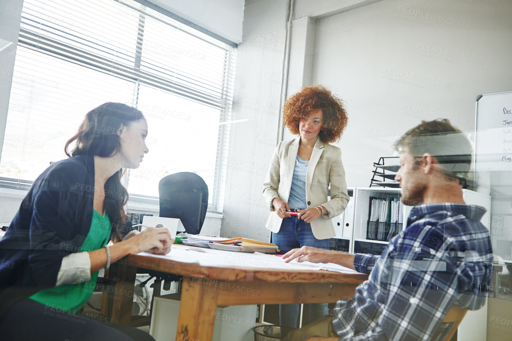 Buy stock photo Cropped shot of three colleagues discussing business in the office