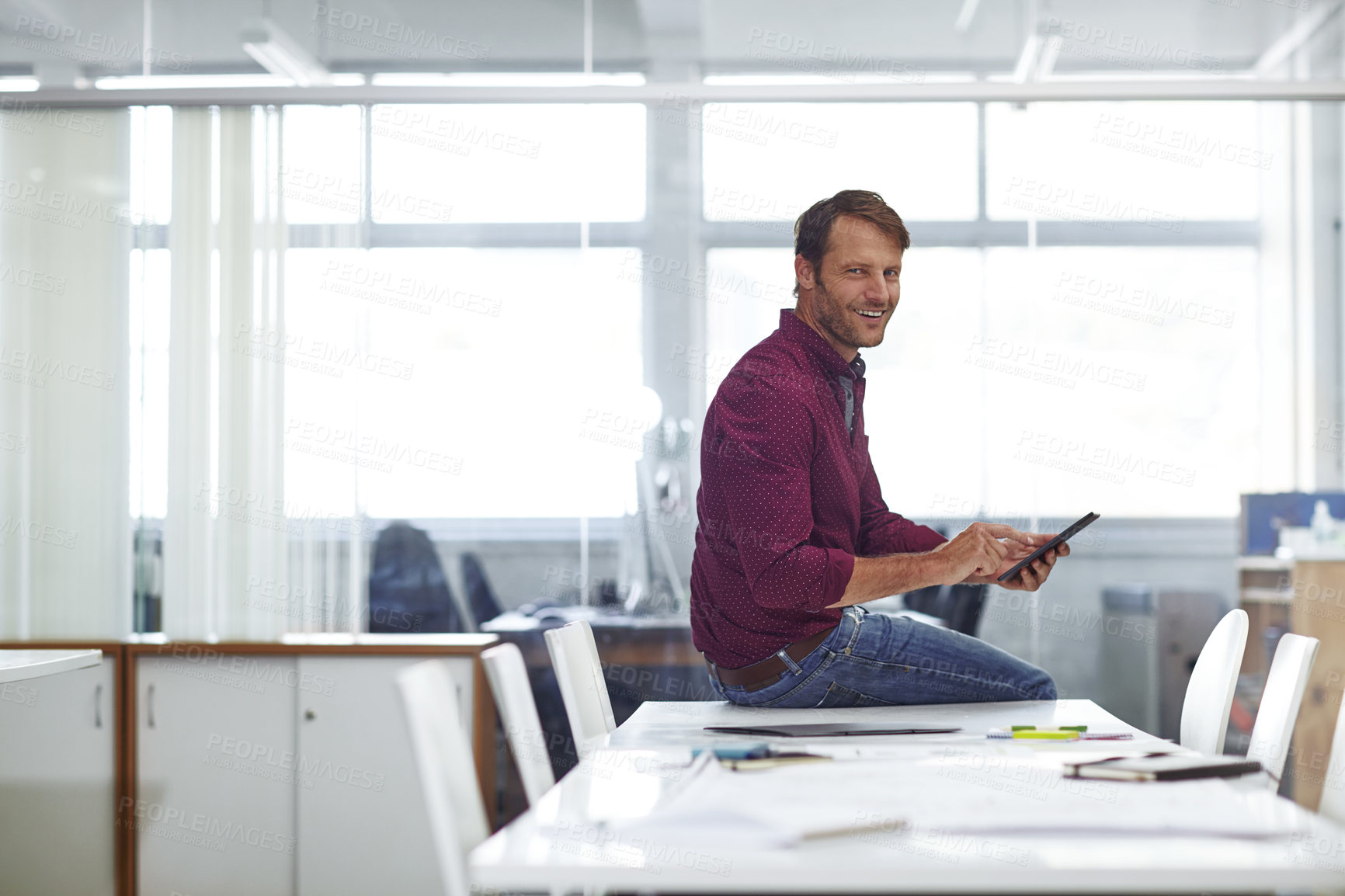 Buy stock photo Cropped shot of a handsome businessman using his tablet in the office