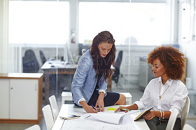 Buy stock photo Shot of two young female designers discussing work in the office