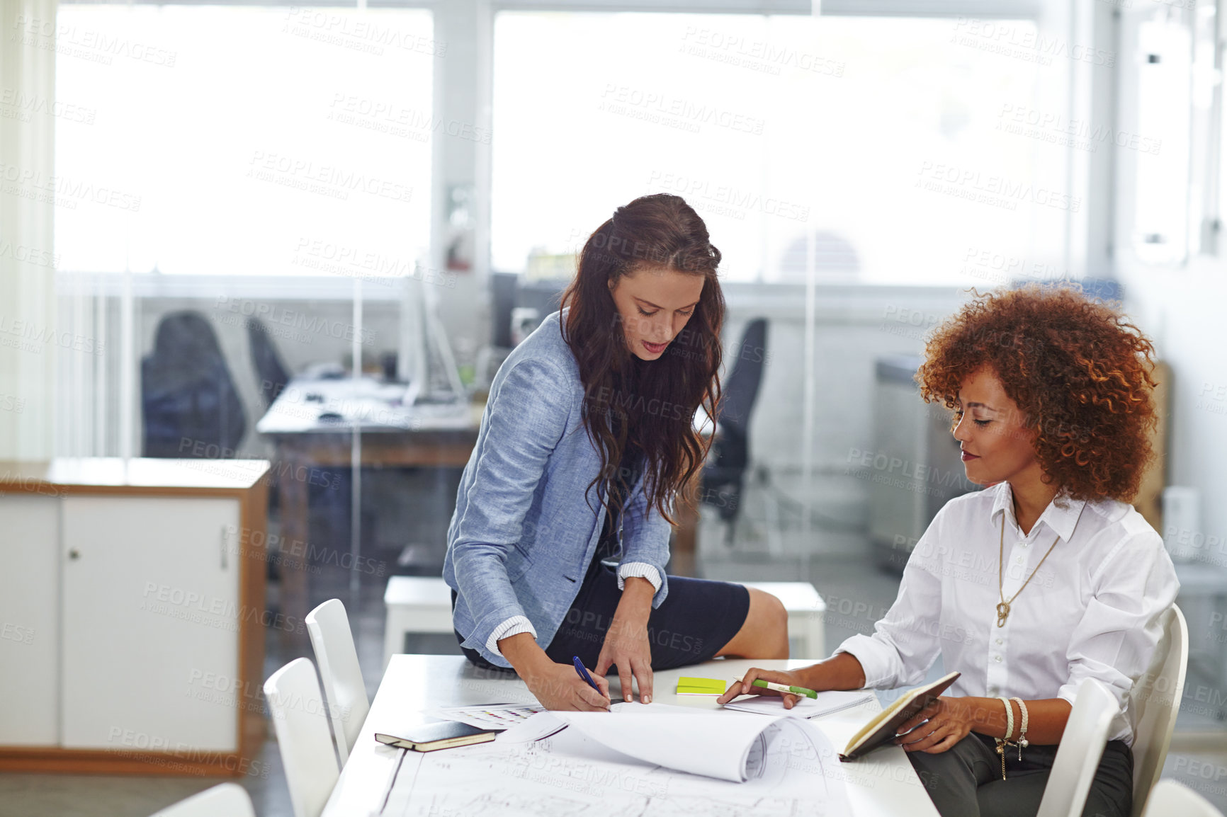 Buy stock photo Shot of two young female designers discussing work in the office