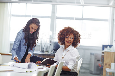 Buy stock photo Shot of two young female designers discussing work in the office