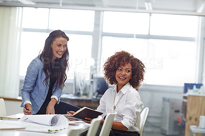 Buy stock photo Shot of two young female designers discussing work in the office