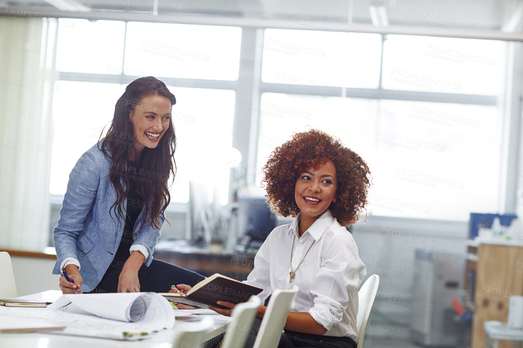 Buy stock photo Shot of two young female designers discussing work in the office