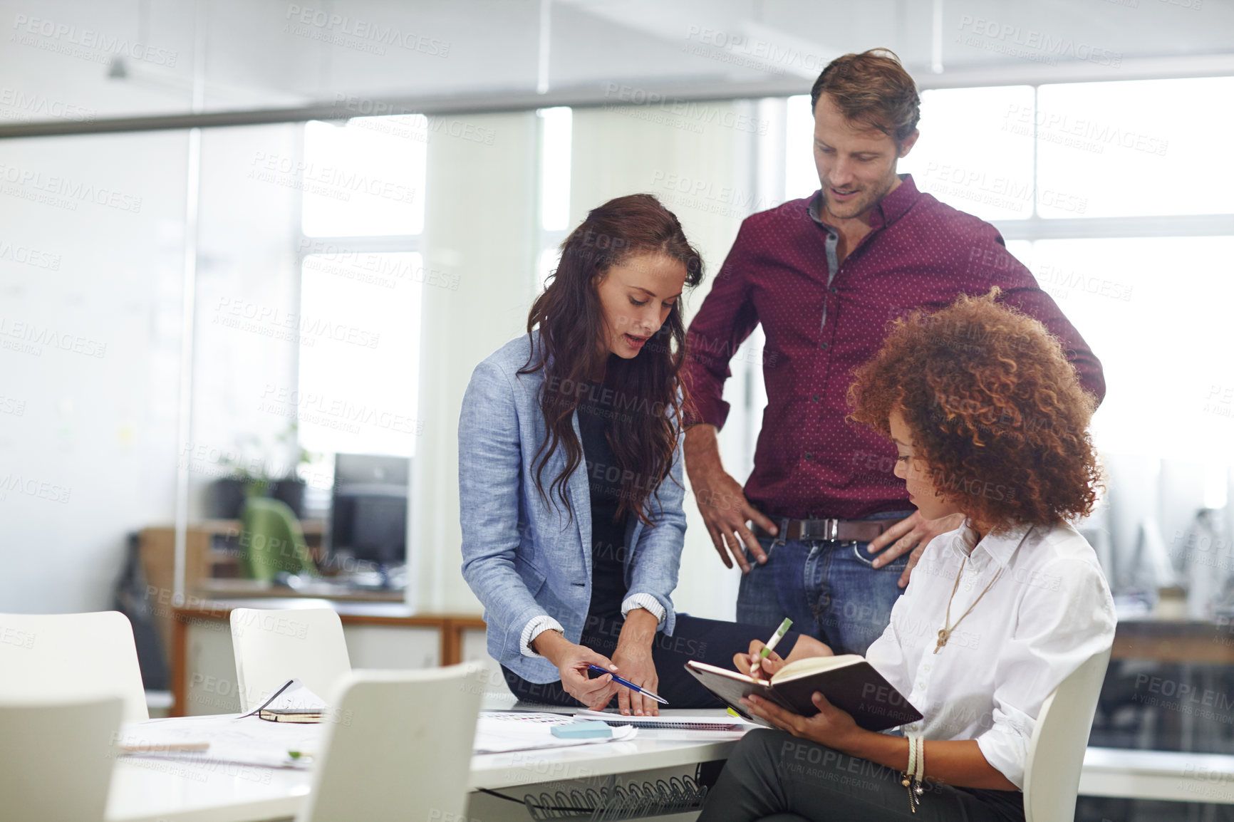 Buy stock photo Cropped shot of three colleagues discussing business in the office