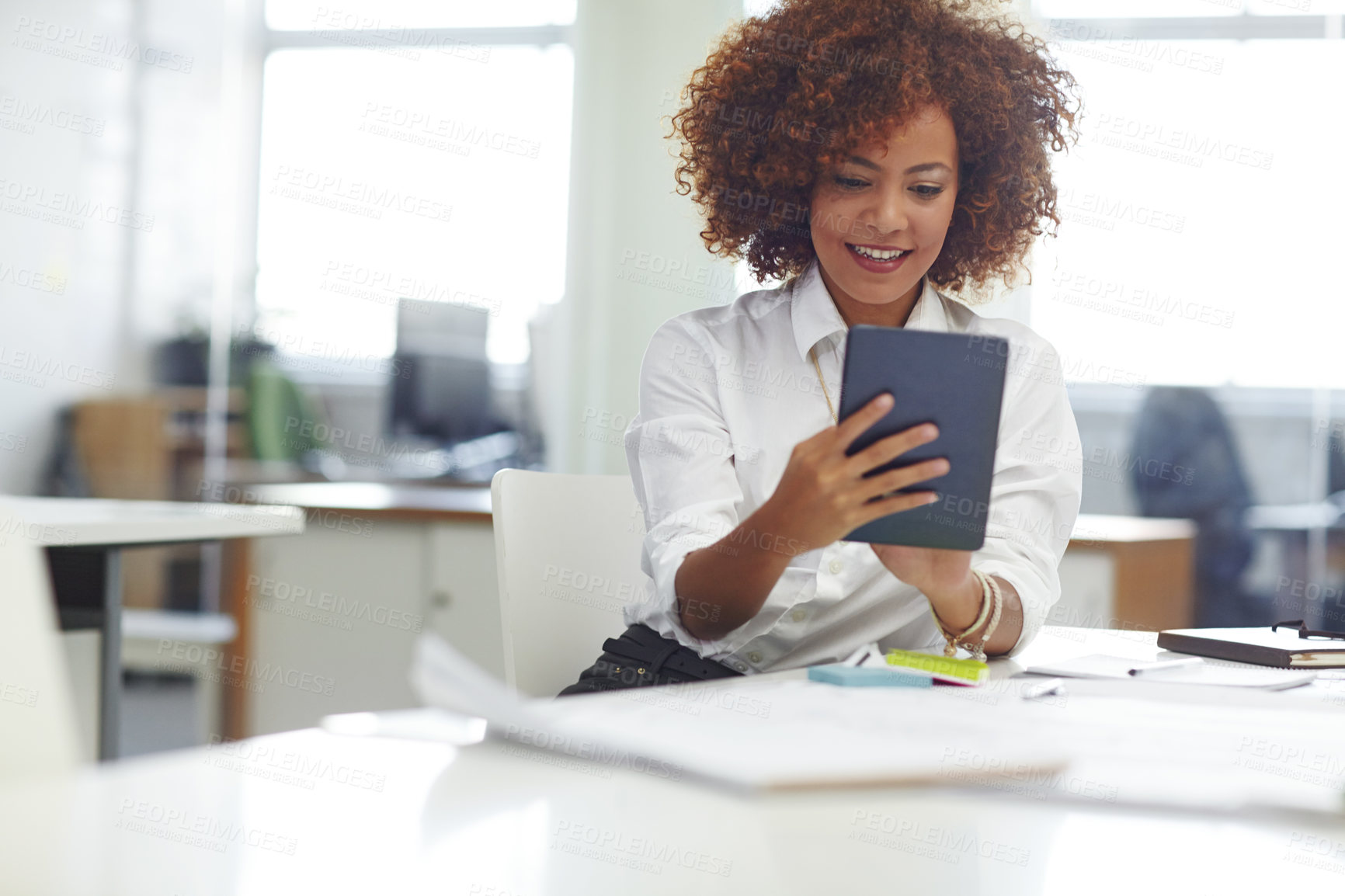 Buy stock photo Cropped shot of a beautiful young businesswoman using her tablet in the office