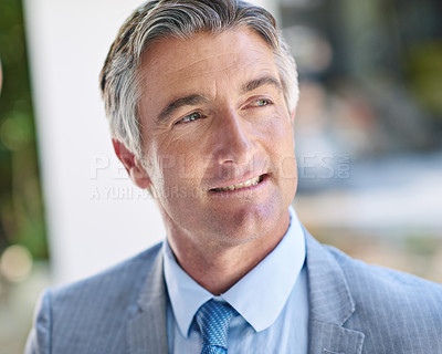 Buy stock photo Shot of a thoughtful-looking mature businessman standing outside