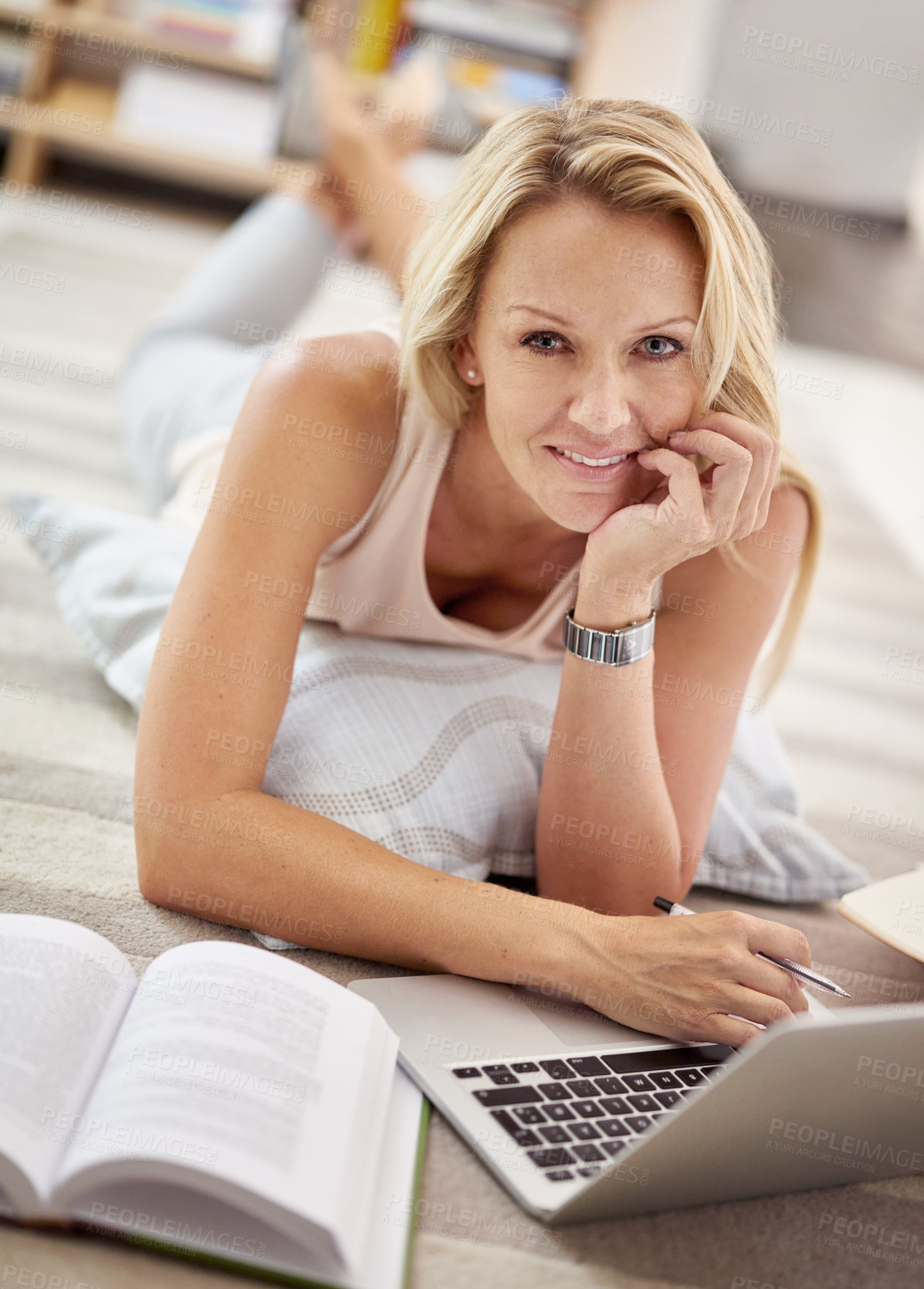 Buy stock photo Portrait of a beautiful mature woman lying on her living room floor doing some research