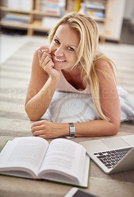 Buy stock photo Portrait of a beautiful mature woman lying on her living room floor doing some research