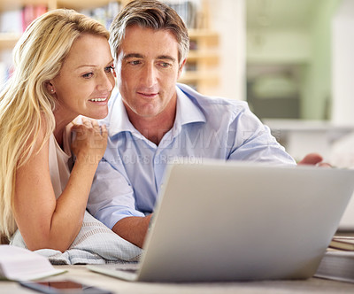 Buy stock photo Shot of a mature couple lying on their living room floor doing some online research