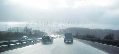 Buy stock photo Cars at breaking distance on a highway on a rainy day in Denmark. Motor vehicles driving on a dangerous asphalt road on a cold misty winter day in a picturesque landscape. Safe driving in bad weather