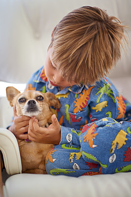 Buy stock photo A little boy petting his dog on the couch