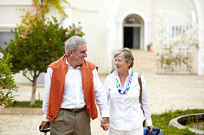 Buy stock photo Holding hands, smile and old couple outside hotel, villa and luggage on luxury retirement vacation together. Marriage, travel and holiday, senior man and woman with suitcase walking in courtyard.