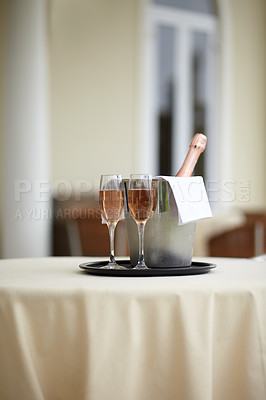 Buy stock photo Hotel, bottle and glasses of champagne on a table for luxury service, celebration and hospitality. Restaurant, wealth and wine, alcohol and drinks at a fine dining establishment for an experience