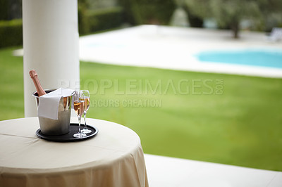 Buy stock photo Hospitality, outdoor and hotel with champagne, glass and pool view for luxury, accommodation and experience. Travel, freedom and table with wine at a villa for service, vacation or romantic getaway