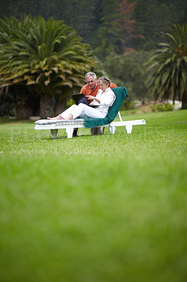Buy stock photo Relax in garden, senior couple with laptop and checking social media, email or holiday post online. Retirement vacation, old man and woman on computer on grass at hotel with trees, nature or internet