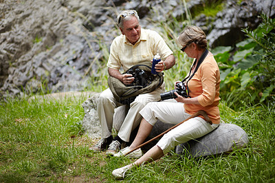 Buy stock photo A loving senior couple stopping for a water break while out for a walk in nature