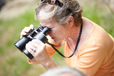 Buy stock photo Senior, woman and binocular in forest for travel, sightseeing or vacation and scenery in nature. Elderly, lady or person in woods for holiday, adventure or experience with hiking, explore or activity