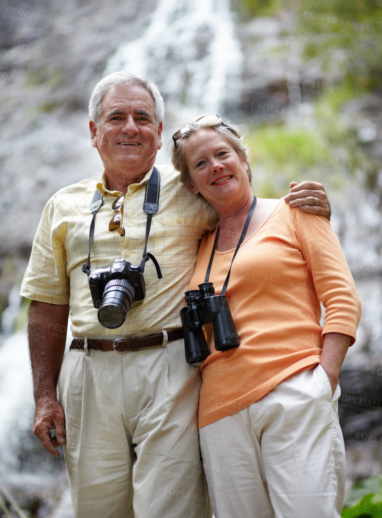 Buy stock photo Portrait of a loving senior couple with binoculars and a camera exploring nature together