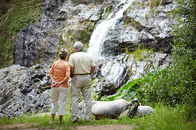 Buy stock photo Back, love and senior couple with vacation, waterfall and nature with holiday, romance and relationship. Romantic, outdoor or elderly man with old woman, fresh air or view with break, forest or relax