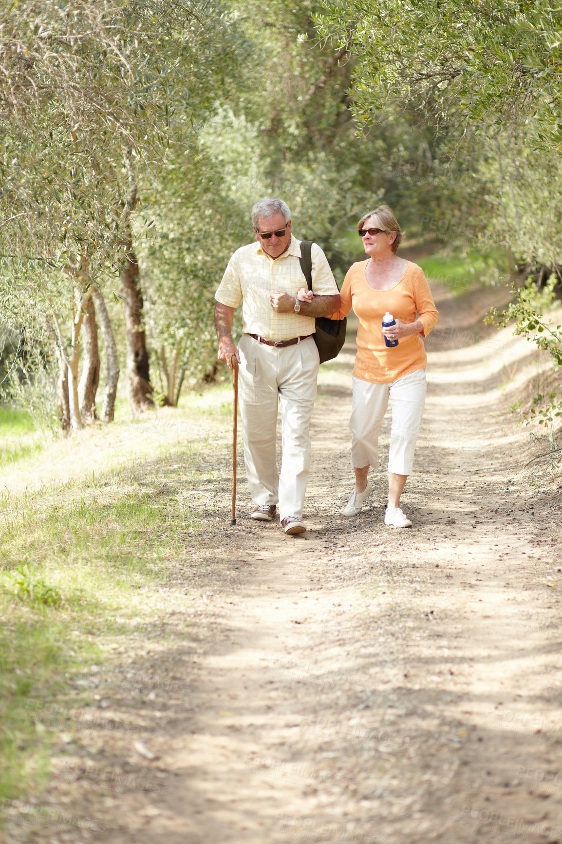 Buy stock photo Hiking, nature and senior couple with walking stick, fitness and retirement exercise, wellness support or path in forest. Elderly people in woods for cardio, eco travel and health journey or trekking