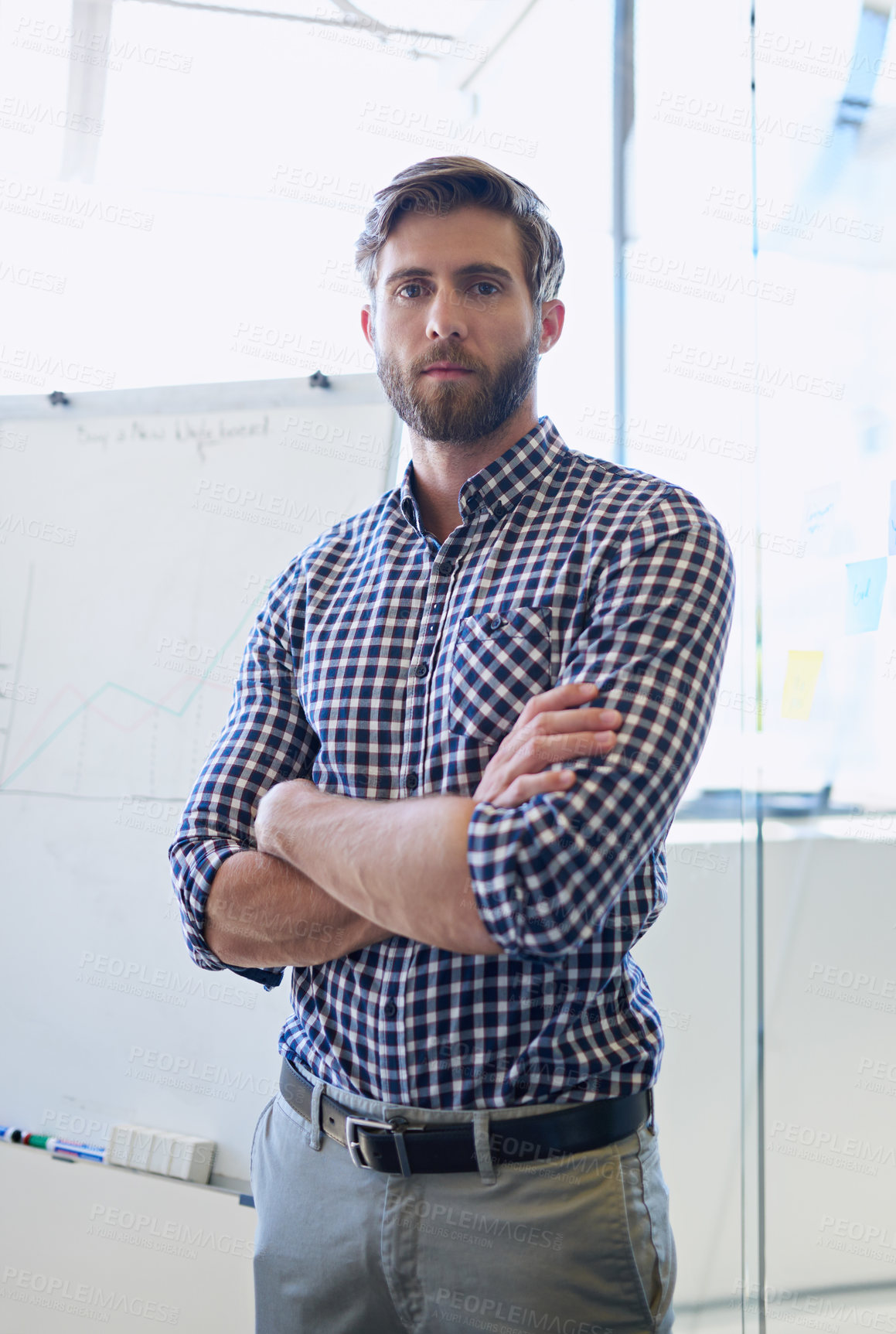 Buy stock photo Cropped portrait of a handsome businessman standing with his arms crossed in the office