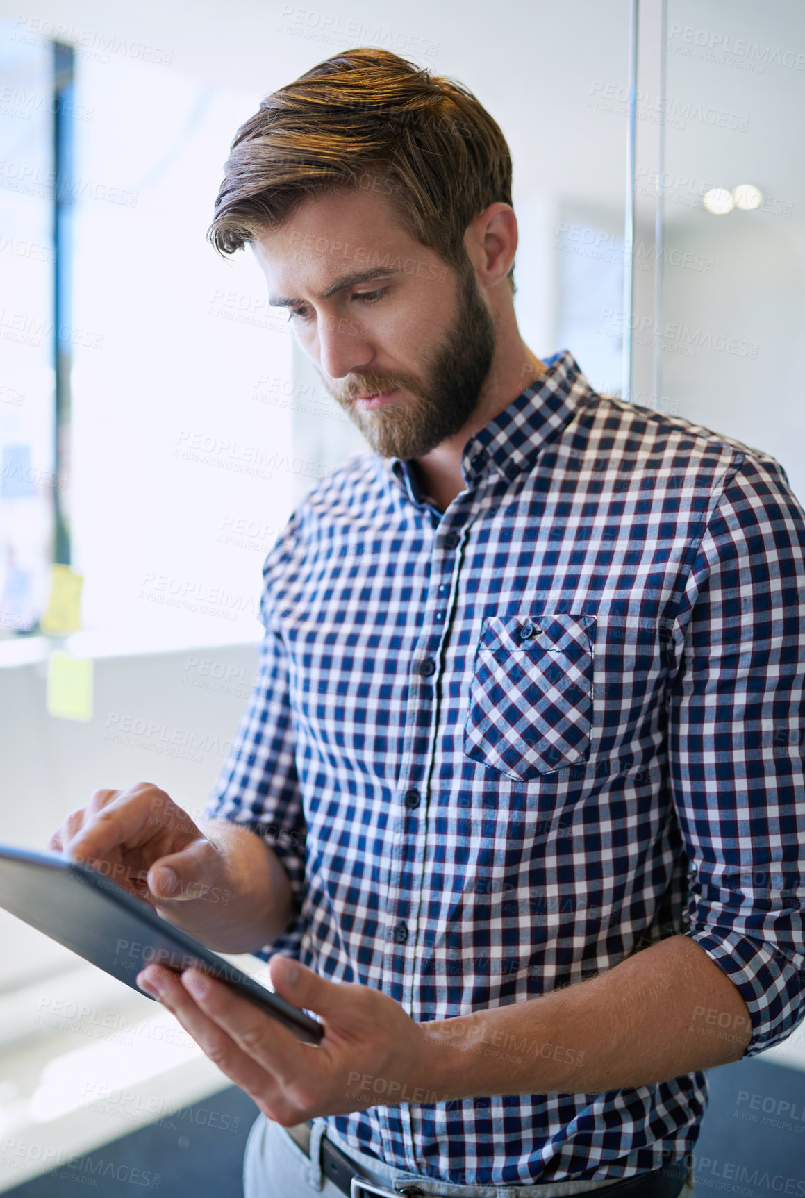 Buy stock photo Serious, business and man at office with tablet on internet for research, reviews or post as social media manager. Male person, employee and texting on website or online for email or communication