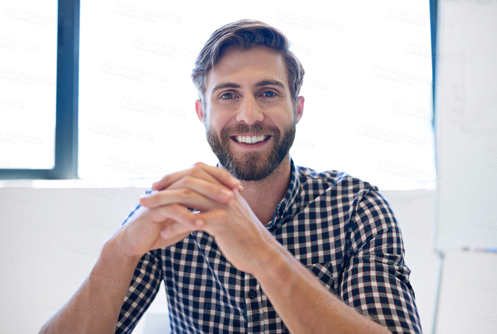 Buy stock photo Portrait of a handsome businessman sitting with his hands clasped in his office