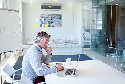 Buy stock photo Cropped shot of a mature businessman working on his laptop at the office