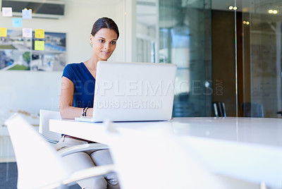 Buy stock photo Cropped shot of a young businesswoman working on her laptop at the office