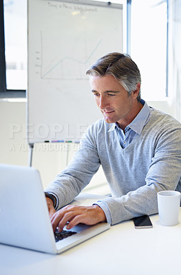 Buy stock photo Cropped shot of a mature businessman working on his laptop at the office