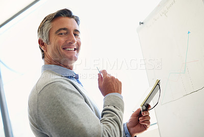Buy stock photo Portrait of a mature business standing at a whiteboard holding a notebook