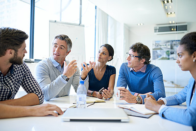 Buy stock photo Shot of a group of businesspeople discussing work during a boardroom meeting