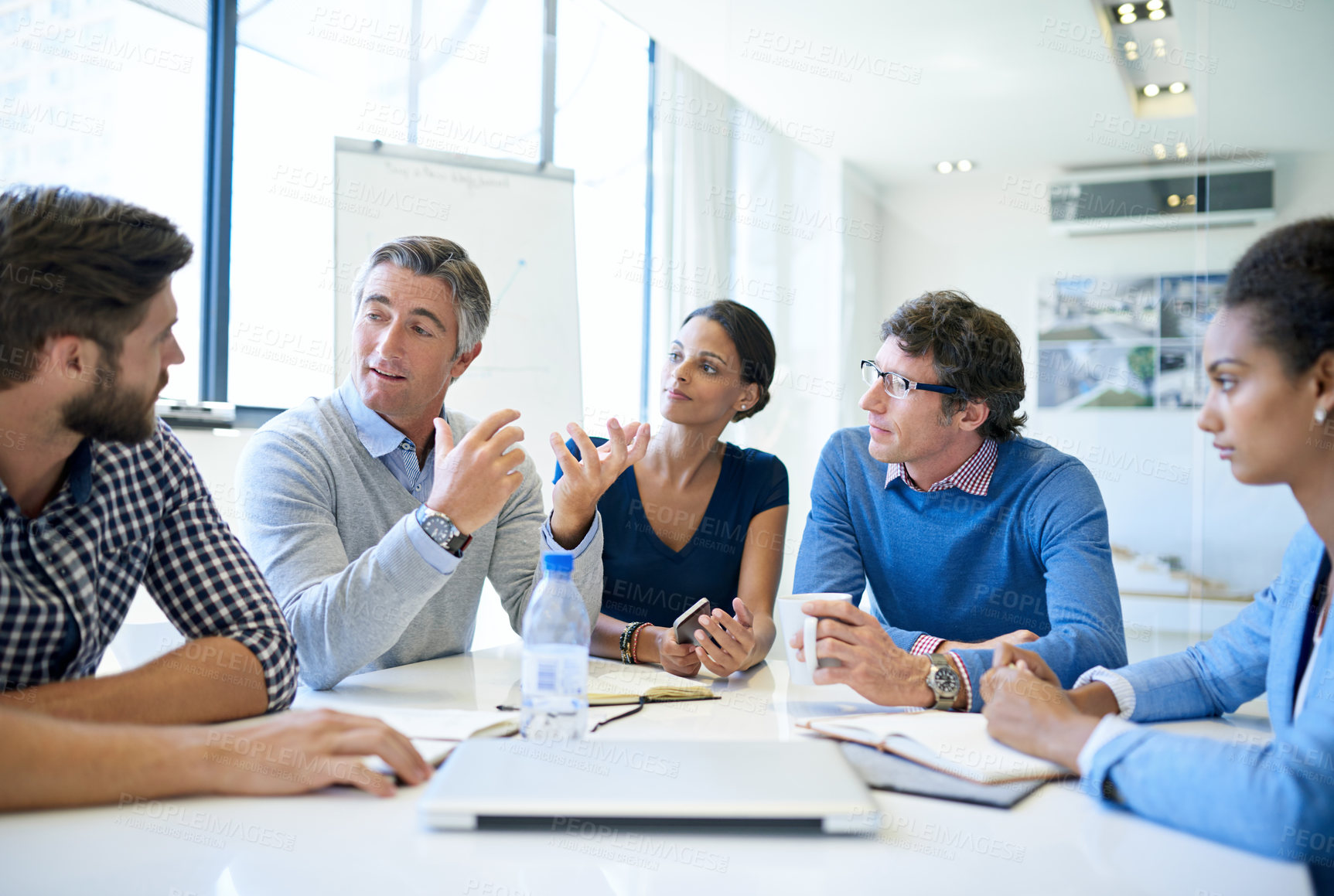 Buy stock photo Shot of a group of businesspeople discussing work during a boardroom meeting