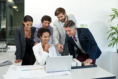 Buy stock photo Shot of a group of businesspeople working together at a laptop