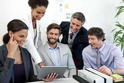 Buy stock photo Shot of a group of businesspeople working together using a digital tablet