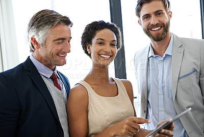 Buy stock photo Shot of coworkers discussing work on a digital tablet