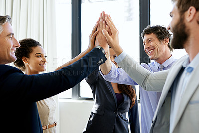 Buy stock photo Shot of a group of excited businesspeople giving each other a high five