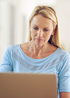 Buy stock photo Shot of a mature woman using a laptop at home