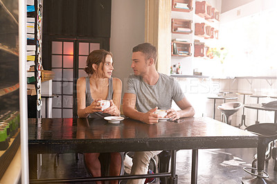 Buy stock photo Shot of a young couple sitting in a coffee shop