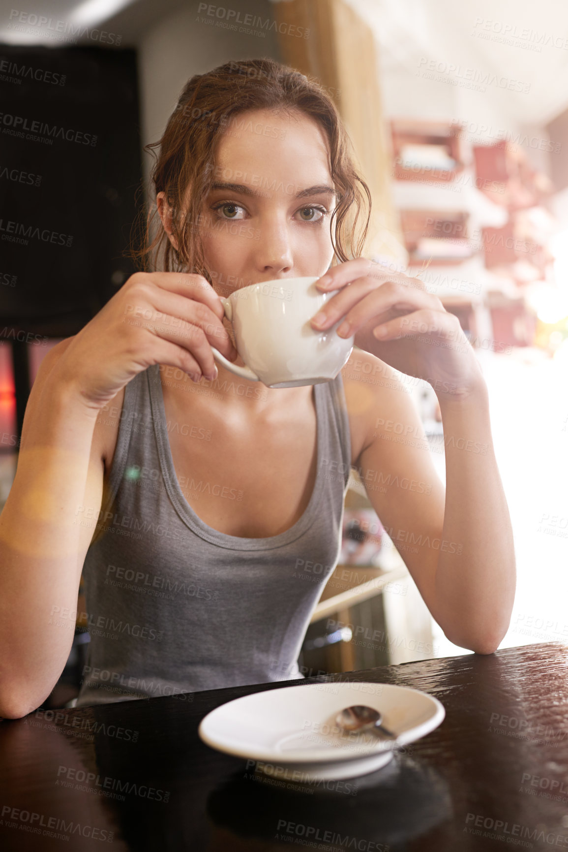 Buy stock photo Cropped shot of a young woman drinking coffee at a cafe