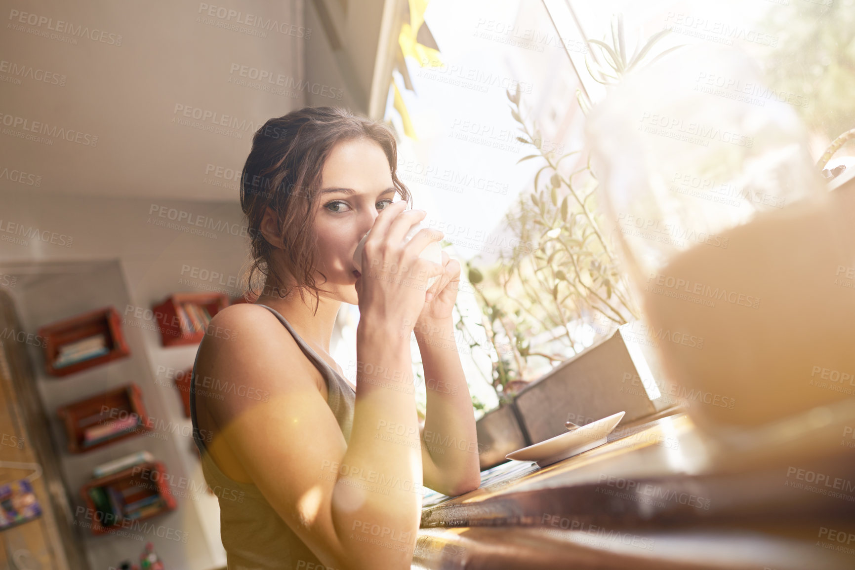 Buy stock photo Cropped shot of a young woman drinking coffee at a cafe