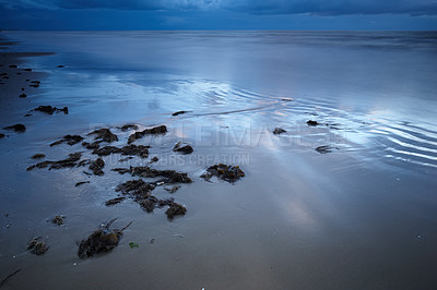 Buy stock photo Blue, sand and water on beach at night with calm, peace or zen outdoor for holiday, travel or vacation. Earth, nature and tide with view of ocean or sea in Denmark for climate, journey or trip