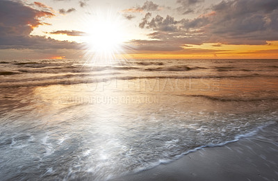 Buy stock photo Sunrise, beach and ocean for vacation, clouds and travel to Denmark for summer holiday adventure. Sea, lens flare and sand on coast with sky, nature or horizon with waves on lands outdoor in Jutland