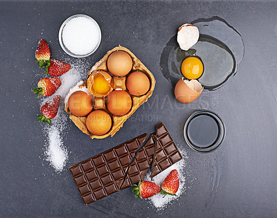 Buy stock photo Top view, baking ingredients or chocolate with eggs, flour and strawberry with sugar on table in kitchen. Fruit, background or cooking products on counter for meal, food recipe or dessert for protein