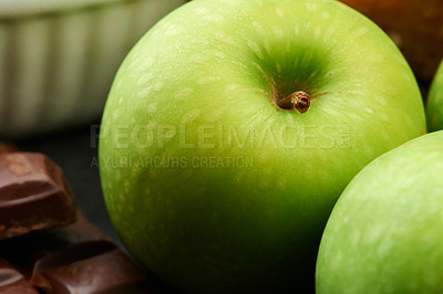 Buy stock photo Closeup, healthy or apple for diet in kitchen of home on counter for diet, natural vitamin c or nutrition. Vegan, background or fruit with sweet chocolate in apartment or house for detox or minerals