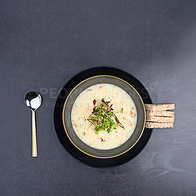 Buy stock photo High angle studio shot of delicious soup and bread sticks on a table